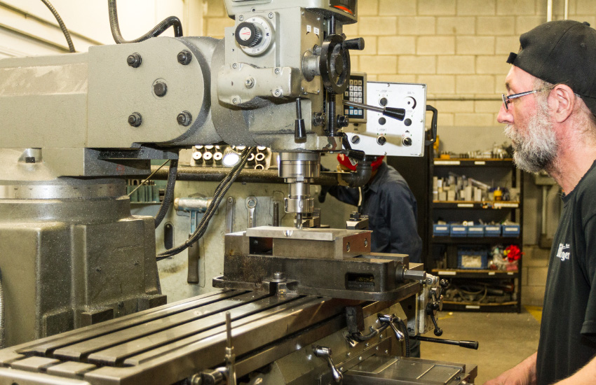 Man in front of a drilling machine